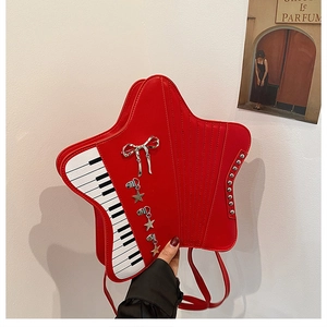 Detail of red star-shaped backpack with piano key print, silver studs and bow charm