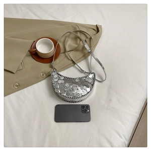 Détail du sac lune à paillettes argentées avec chaîne et finitions tressées