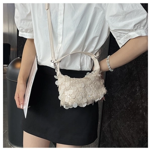 Detail of cream sequin crossbody bag showing the shimmering texture and leather strap