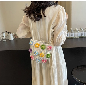 Detailed view of handmade woven crossbody bag with colorful 3D crochet floral decorations