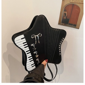 Detail of star-shaped crossbody bag with piano key patterns and silver charms