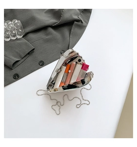 Detailed interior of heart shaped silver metal clutch bag with chain strap and essentials