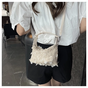 Detailed macro view of a cream sequined hobo bag featuring shimmering paillette textures