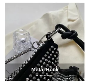 Detail view of silver hardware hook and woven handle on black rhinestone handbag