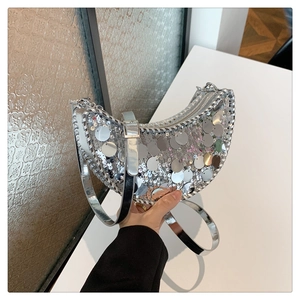 Détail du sac croissant argenté à paillettes avec bords tressés et bandoulière métal
