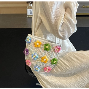 Close-up of white crochet bucket bag featuring colorful 3D handmade floral decorations