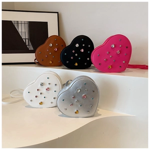 Detailed view of heart-shaped crossbody bags featuring colorful rhinestones and metal studs