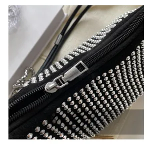 Close-up of smooth silver metal zipper and cone studs on black canvas shoulder bag