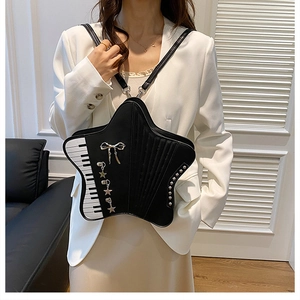 Detailed view of star-shaped crossbody bag featuring piano keys and silver bow accents