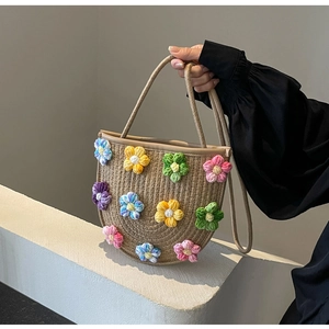 Detailed close-up of handmade woven crossbody bag with colorful crochet flower patterns