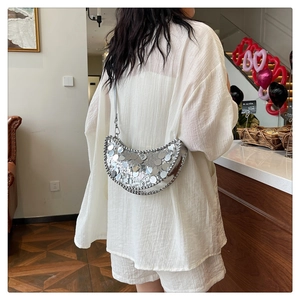 Détail du sac hobo à paillettes argentées montrant la texture brillante et forme lune