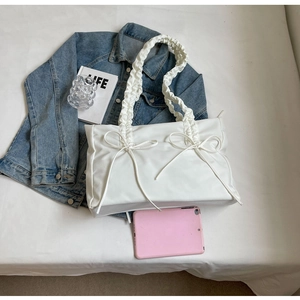 Detail van witte shopper met schouderband met ruches en decoratieve strikjes