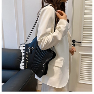 Detail of star-shaped crossbody bag with piano key patterns and metallic bow charms