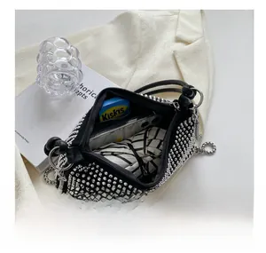 Top view of black rivet shoulder bag interior showing phone and daily essentials