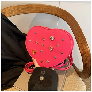 Detail of pink heart-shaped bag with colorful rhinestones and silver star studs