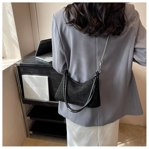 Detail view of black rhinestone shoulder bag on model with silver chain strap