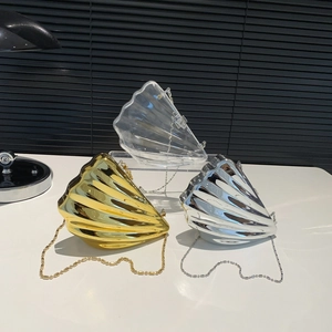 Shell-shaped acrylic crossbody clutch bags in gold, silver, and transparent finishes with chain