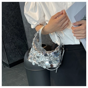 Detail of silver sequin mini shoulder bag worn with metallic reflective texture effects