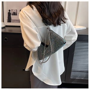 Detail of a geometric black rhinestone shoulder bag with iridescent crystals and chain strap