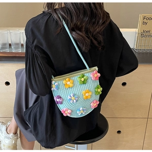 Detail of light blue hand-woven shoulder bag with colorful 3D crochet flowers