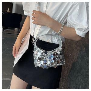 Detailed side view of silver sequin crossbody bag with metallic sheen and millennium style