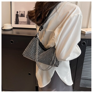 Detailed view of black rhinestone hobo bag with silver chain strap shown on a model