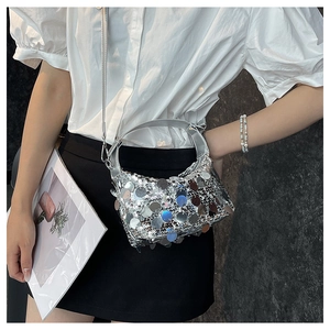 Detail of silver sequin crossbody bag with metallic discs and minimalist fashion styling