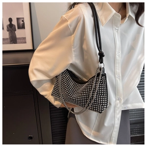Close-up of black rhinestone underarm bag with silver chain and leather strap