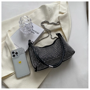 Detail of black rhinestone underarm bag featuring sparkling silver crystals and metal chain