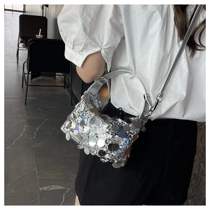 Silver crossbody bag with large round sequins and adjustable shoulder strap shown on model