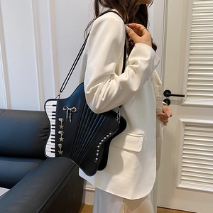 Star-shaped black leather tote bag with piano key patterns and silver charms