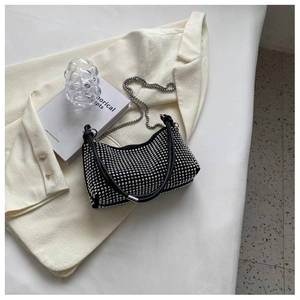 Detail of silver rhinestones on black crescent shoulder bag with metallic chain strap