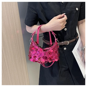 Close-up of vibrant rose pink paillette sequins on a modern crescent-shaped handbag