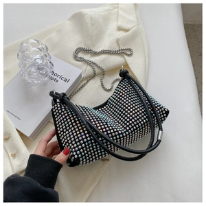 Close-up of sparkling black rhinestone handbag with silver metal chain on elegant background