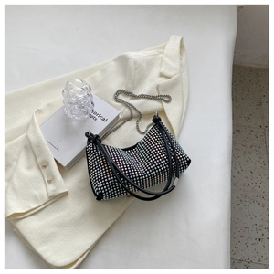 Detail of colorful rhinestones on a black handbag with a silver chain strap