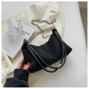 Close-up of black rhinestone texture with silver chain strap on a women handbag