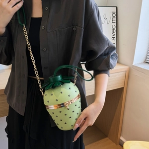 Quirky strawberry shaped crossbody bag in bright green with gold chain and leaf top handle
