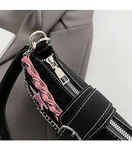 Detail of silver zipper and pink ruffle trim on black y2k shoulder bag with contrast stitching