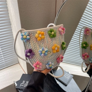 Handmade woven crossbody bag with colorful knit flowers and thin white shoulder strap