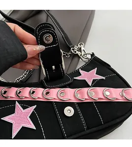 Detail of silver metallic buckle and pink star embroidery on y2k style black shoulder bag