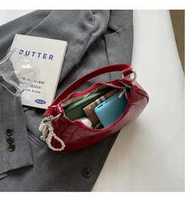 Macro detail of red leather handbag interior with pearl charm and spacious storage