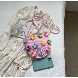 Handmade pink woven crossbody bag with colorful crochet flowers in a soft aesthetic style