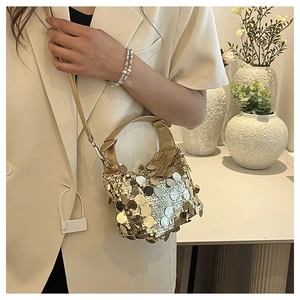 Macro view of champagne gold sequin handbag showing metallic texture and leather strap