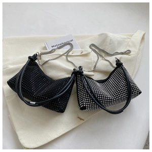 Detail of studded tote bags in black and silver finishes with elegant metal chain straps