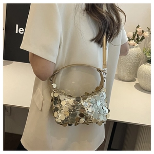 Detail of shimmering gold oversized sequins on hobo bag with adjustable shoulder strap