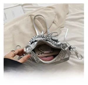 Detailed interior of a silver quilted bag showing storage for phone, wallet and makeup