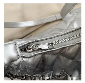 Detail of silver metallic quilted bag showing high-quality zipper and chain strap