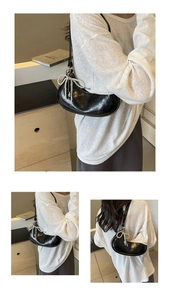 Detail of black leather dumpling bag featuring a pearl bow pendant and soft pleated texture