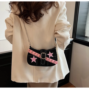 Close-up of Y2K style black crossbody bag with pink stars and metal eyelet details