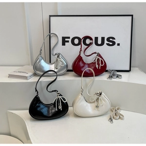 Detail of four crescent moon bags in silver, burgundy, black and white with pearl charms